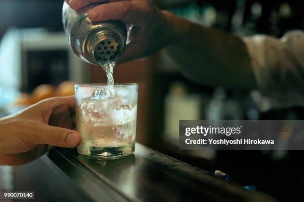 close-up of bartender hand pouring cocktail - 酒場　日本 ストックフォトと画像