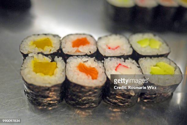 sushi rolls wrapped in seaweed with salmon and vegetables - rohkosternährung stock-fotos und bilder