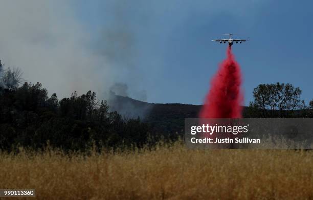 Firefighting air tanker drops Foscheck fire retardant on a hillside ahead of the County Fire on July 2, 2018 in Guinda, California. The fast moving...