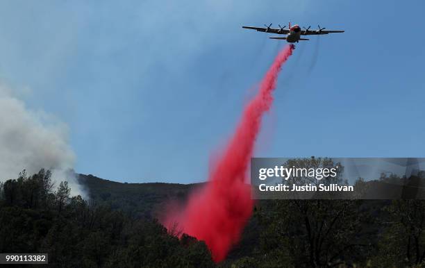 Firefighting air tanker drops Foscheck fire retardant on a hillside ahead of the County Fire on July 2, 2018 in Guinda, California. The fast moving...