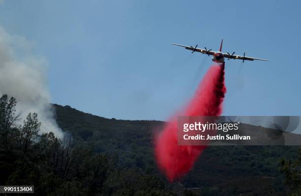Firefighting air tanker drops Foscheck fire retardant on a hillside ahead of the County Fire on July 2, 2018 in Guinda, California. The fast moving...