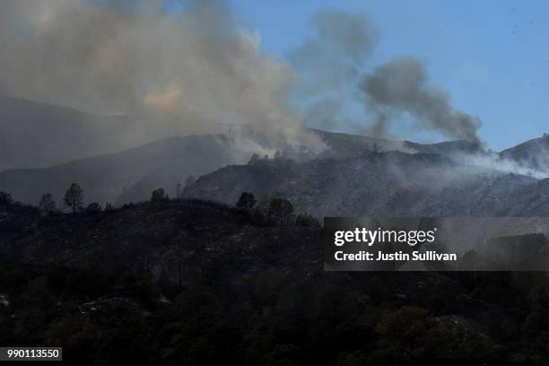 Smoke rises from the County Fire as it burns through dry brush on July 2, 2018 in Guinda, California. The fast moving County Fire, that started on...