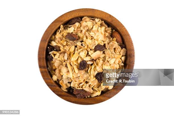 top close view of a dry mix of fruit and almond nuts cereal in a wooden bowl - close up counter ストックフォトと画像