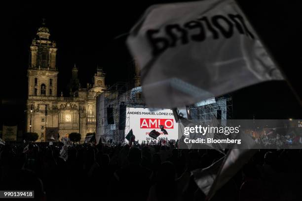Supporters wave flags during an election night rally for Andres Manuel Lopez Obrador, Mexico's president-elect, at Zocalo square in Mexico City,...