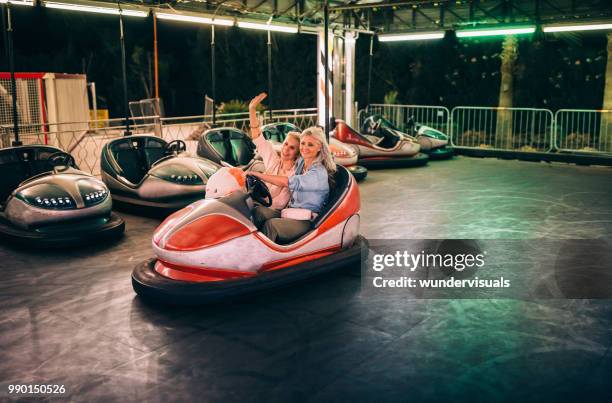 gerne reife frauen fahren autoscooter im freizeitpark - autoscooter stock-fotos und bilder