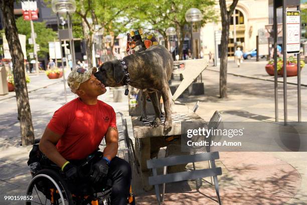 Desert Storm veteran Tony Drees gets love from his service dog Diva, a two year old Italian mastiff, on the16th St Mall. Drees has undergone 74...