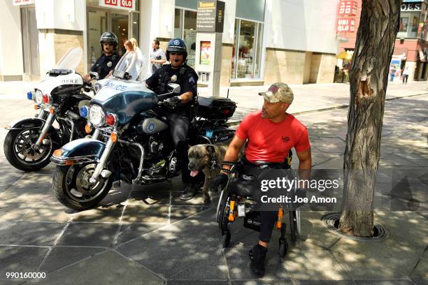 Desert Storm veteran Tony Drees and his service dog Diva, a two year old Italian mastiff, talk with the Denver Police on the16th St Mall. Drees has...