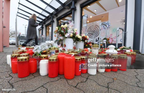 Flowers and candles lying on the floor in front of a pharmacy in remembrance of a 15-year old girl, who was stabbed by her boyfriend on 27 December...