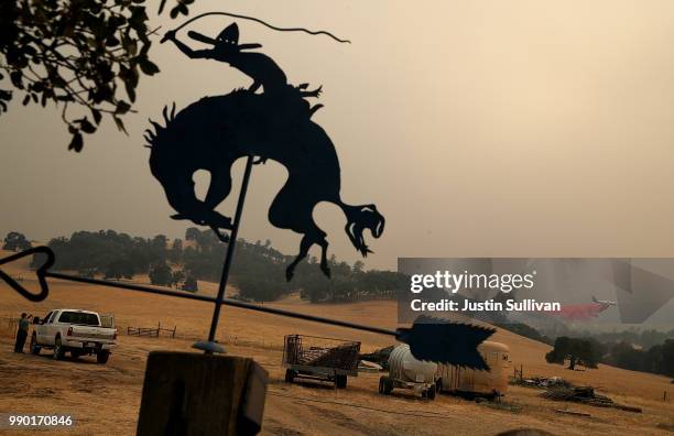 Firefighting air tanker drops Foscheck fire retardant on a hillside ahead of the County Fire on July 2, 2018 in Esparto, California. The fast moving...