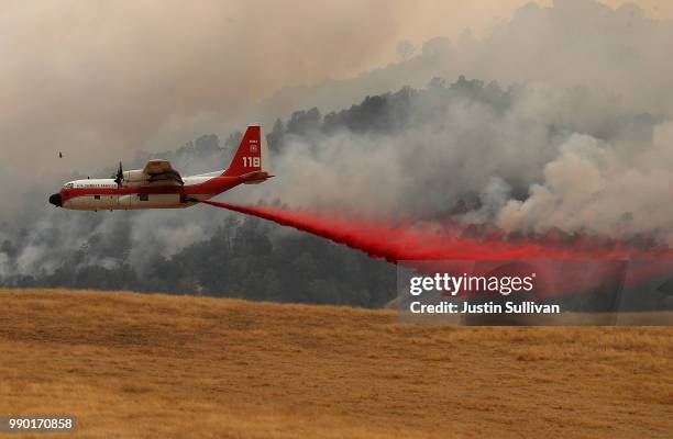 Firefighting air tanker drops Foscheck fire retardant on a hillside ahead of the County Fire on July 2, 2018 in Esparto, California. The fast moving...