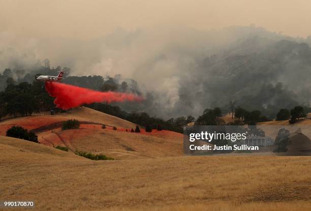 Firefighting air tanker drops Foscheck fire retardant on a hillside ahead of the County Fire on July 2, 2018 in Esparto, California. The fast moving...