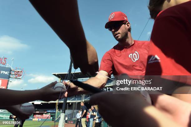 Young fans ask for autographs from pitcher Max Scherzer after the batting practice of Washington Nationals baseball players before a game at the...