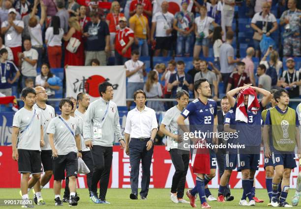 Japan coach Akira Nishino and players leave the pitch after a World Cup round-of-16 match against Belgium in Rostov-On-Don, Russia, on July 2, 2018....