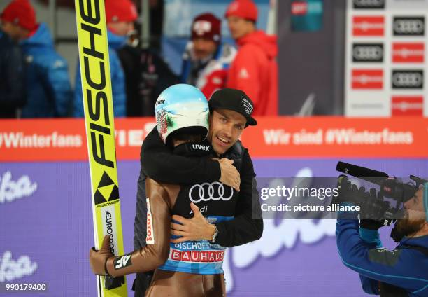 Kamil Stoch of Poland embraces Sven Hannawald after his jump in the second round at the Four Hills Tournament in Bischofshofen, Austria, 6 January...