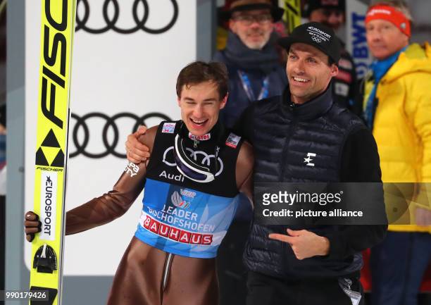 Kamil Stoch of Poland celebrates with Sven Hannawald after his jump in the second round at the Four Hills Tournament in Bischofshofen, Austria, 6...