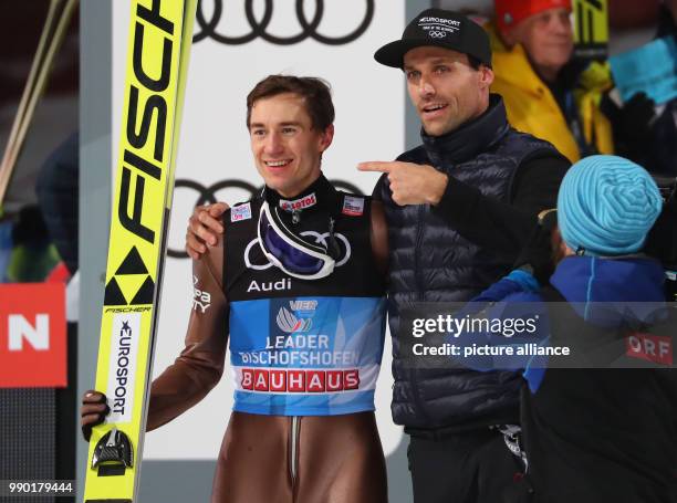 Kamil Stoch of Poland celebrates with Sven Hannawald after his jump in the second round at the Four Hills Tournament in Bischofshofen, Austria, 6...