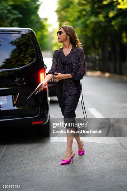 Carine Roitfeld wears a balck ruffled top, a black skirt, pink shoes, outside Giambattista Valli, during Paris Fashion Week Haute Couture Fall Winter...