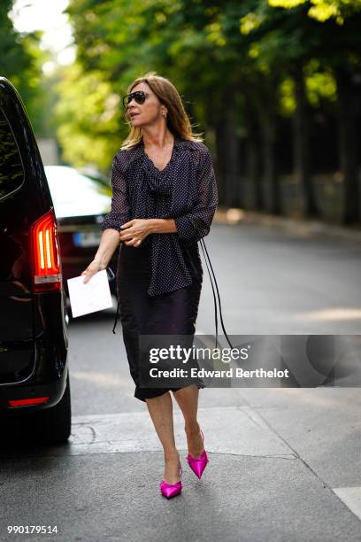 Carine Roitfeld wears a balck ruffled top, a black skirt, pink shoes, outside Giambattista Valli, during Paris Fashion Week Haute Couture Fall Winter...