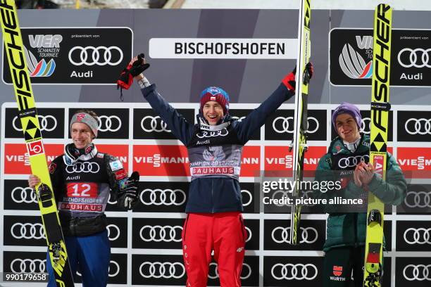 Kamil Stoch of Poland celebrates as he stands between Andreas Wellinger of Germany and Anders Fannemel of Norway after winning all four jumps at the...