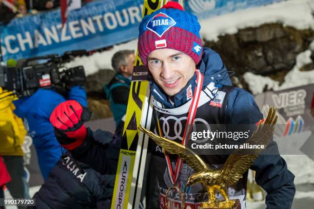 Kamil Stoch of Poland celebrates holding the trophy in his hand after his final jump at the 66th Four Hills Tournament in Bischofshofen, Austria, 6...