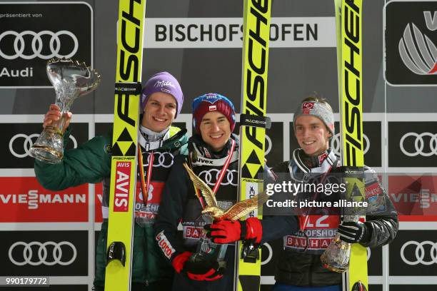 Kamil Stoch of Poland celebrates with Andreas Wellinger of Germany and Anders Fannemel of Norway after winning all four jumps at the Four Hills...