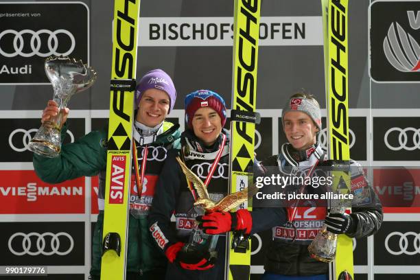 Kamil Stoch of Poland celebrates with Andreas Wellinger of Germany and Anders Fannemel of Norway after winning all four jumps at the Four Hills...