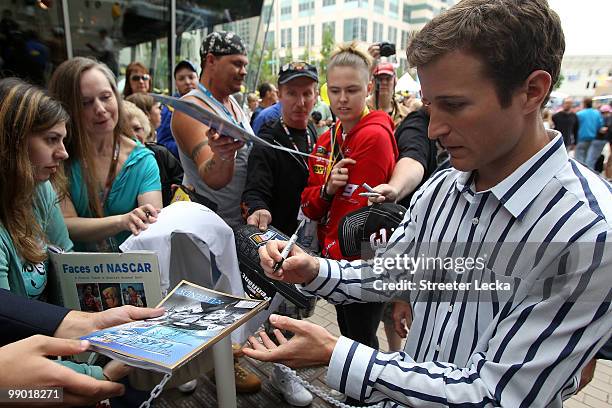 Driver Kasey Kahne signs autographs for fans outside during the NASCAR Hall of Fame Grand Opening at the NASCAR Hall of Fame on May 11, 2010 in...