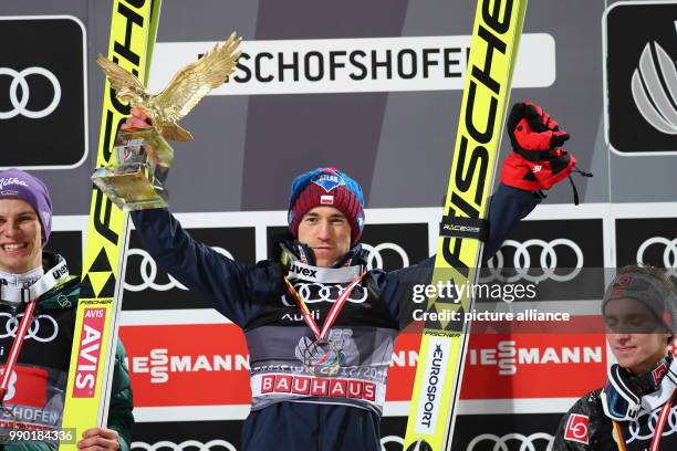 Kamil Stoch of Poland celebrates holding the trophy in his hand after his final jump at the Four Hills Tournament in Bischofshofen, Austria, 6...