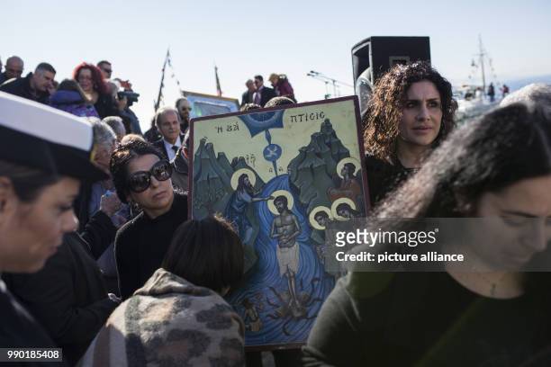 Orthodox Christian faithfuls carry a picture of the Lord during the annual Epiphany Day celebrations in Piraeus near Athens, Greece, 06 January 2018....