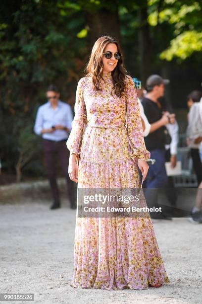 Anouchka Delon wears a pink flower print pleated dress, outside Giambattista Valli, during Paris Fashion Week Haute Couture Fall Winter 2018/2019, on...