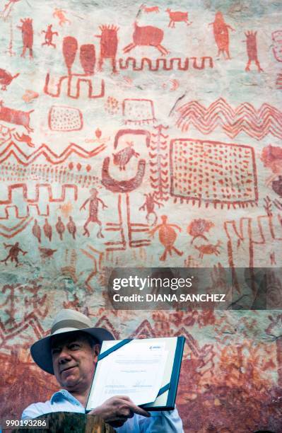 Colombian President Juan Manuel Santos shows the document through which the Chiribiquete National Park -named UNESCO's World Heritage site on the...