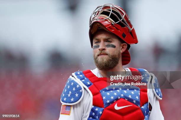 Tucker Barnhart of the Cincinnati Reds looks on while wearing special Fourth of July chest protector and uniform in the first inning against the...