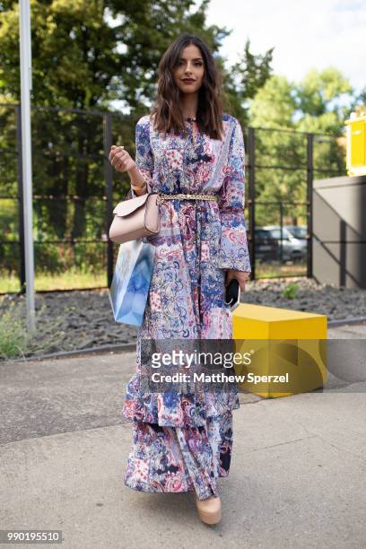 Guest is seen on the street wearing a colorful floral pattern dress with gold belt during the Berlin Fashion Week July 2018 on July 2, 2018 in...