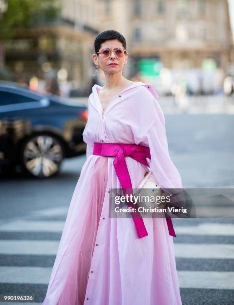 Guest wearing a pink coat is seen outside Schiaparelli on day two during Paris Fashion Week Haute Couture FW18 on July 2, 2018 in Paris, France.