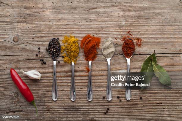 different spices on a black wooden surface - allspice stock-fotos und bilder