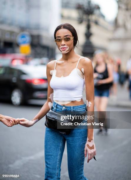 Winnie Harlow wearing denim jeans, belt bag, white top is seen outside Schiaparelli on day two during Paris Fashion Week Haute Couture FW18 on July...