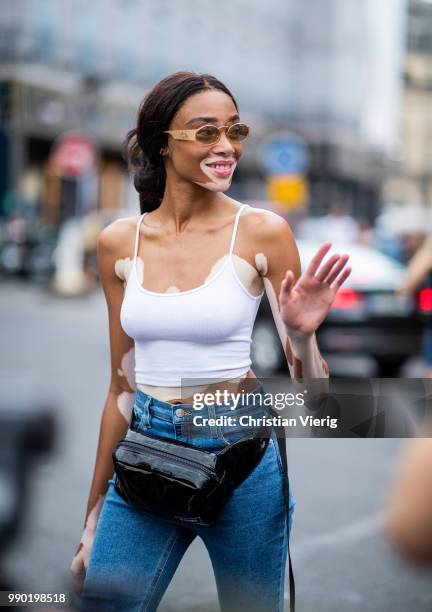 Winnie Harlow wearing denim jeans, belt bag, white top is seen outside Schiaparelli on day two during Paris Fashion Week Haute Couture FW18 on July...