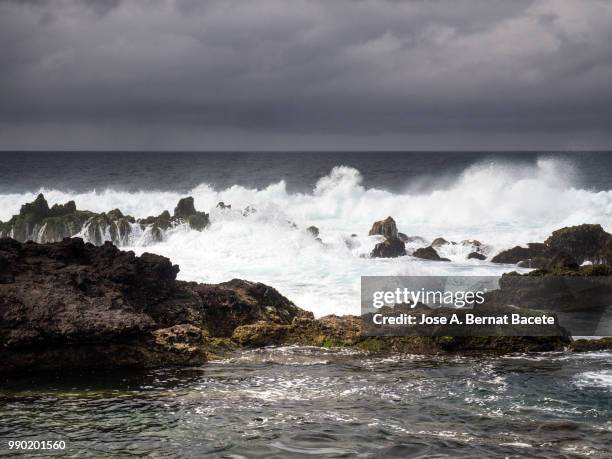 marine landscape with sky of storm, impact of the waves on the volcanic rocks of the coast in terceira island in the azores islands, portugal. - island in the sky stock pictures, royalty-free photos & images