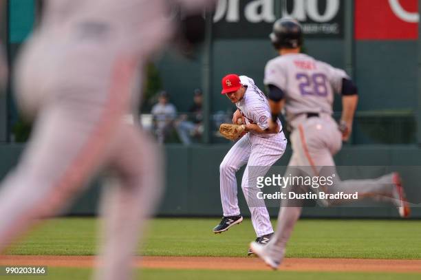 LeMahieu of the Colorado Rockies handles a ground ball hit by Madison Bumgarner of the San Francisco Giants before forcing him out to end the top of...