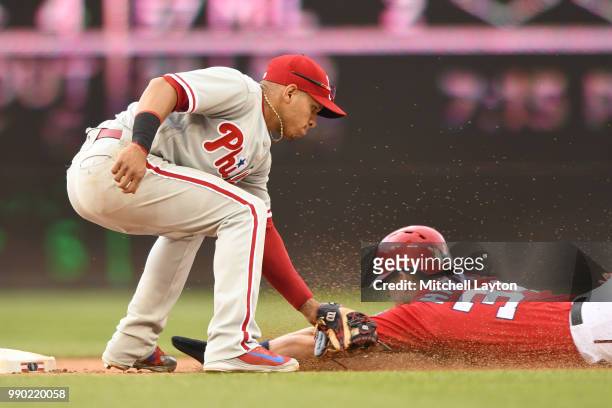 Cesar Hernandez of the Philadelphia Phillies tags out Bryce Harper of the Washington Nationals trying to steal second base during a baseball game at...