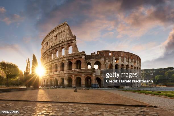 sunlight through the colosseum in rome - rom stock-fotos und bilder