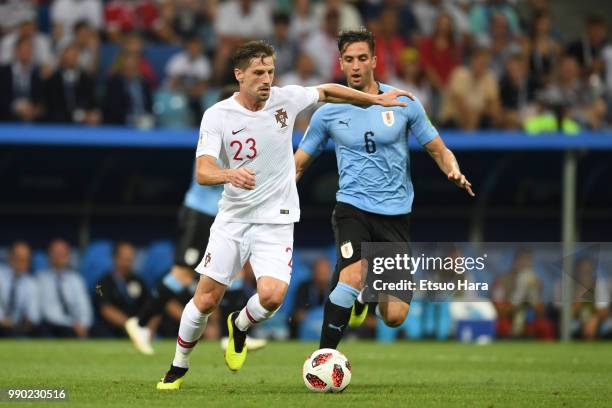 Adrien Silva of Portugal and Rodrigo Bentancur of Uruguay compete for the ball during the 2018 FIFA World Cup Russia Round of 16 match between...