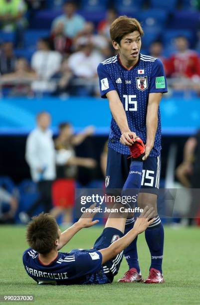 Yuya Osako helps Genki Haraguchi of Japan during the 2018 FIFA World Cup Russia Round of 16 match between Belgium and Japan at Rostov Arena on July...
