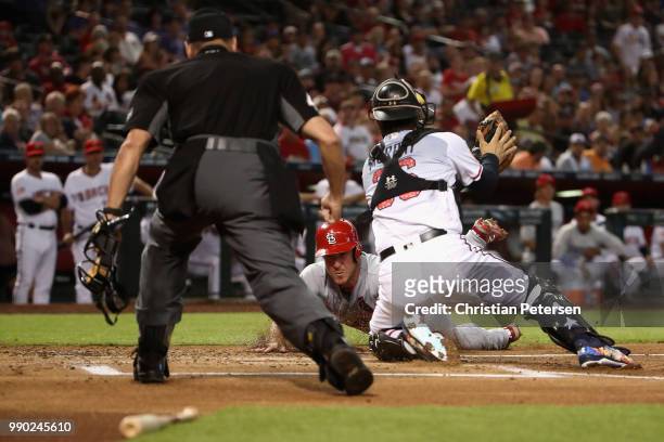 Jedd Gyorko of the St. Louis Cardinals is tagged out at home plate by catcher John Ryan Murphy of the Arizona Diamondbacks during the first inning of...