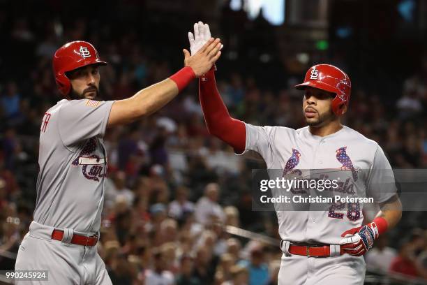 Tommy Pham and Matt Carpenter of the St. Louis Cardinals high five after both scored runs against the Arizona Diamondbacks during the first inning of...