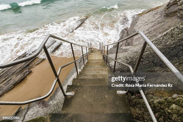 access stairway to beach on the sea at high tide, before summer storm, san sebastian, guipúzcoa, spain, europe. - rz fotografías e imágenes de stock