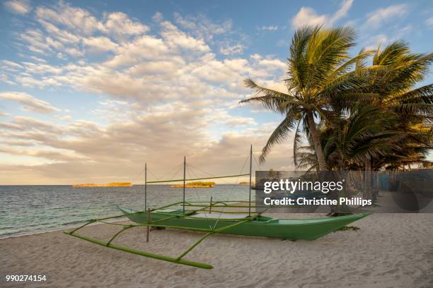 a boat on a beach in boracay in philippines later afternoon under palm trees - boracay philippines stock pictures, royalty-free photos & images
