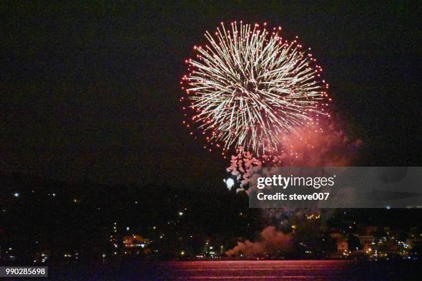 picture taken from tarrytown new york right at the hudson river showing the annual nyack new york annual fourth of july fireworks celebration held on saturday june 30th in memorial park in nyack new york. photo taken saturday june 30, 2018. - tarrytown foto e immagini stock