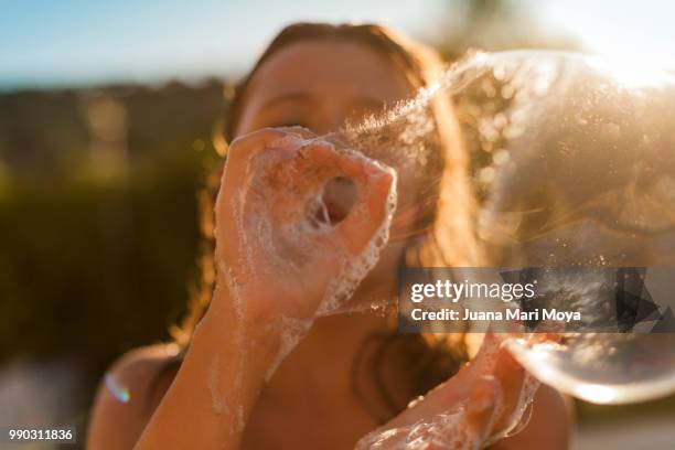 girl making a big bubble of soap with her hands. - hot big women stockfoto's en -beelden