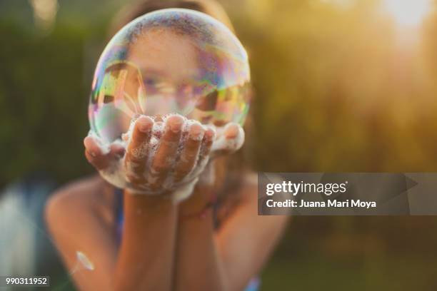 girl shows a big bubble of soap on her hands. - bubble wand ストックフォトと画像